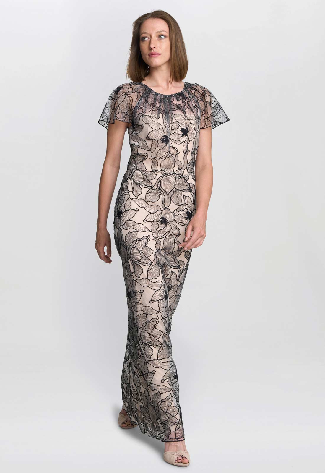 Woman wearing a black floral lace dress on a white background