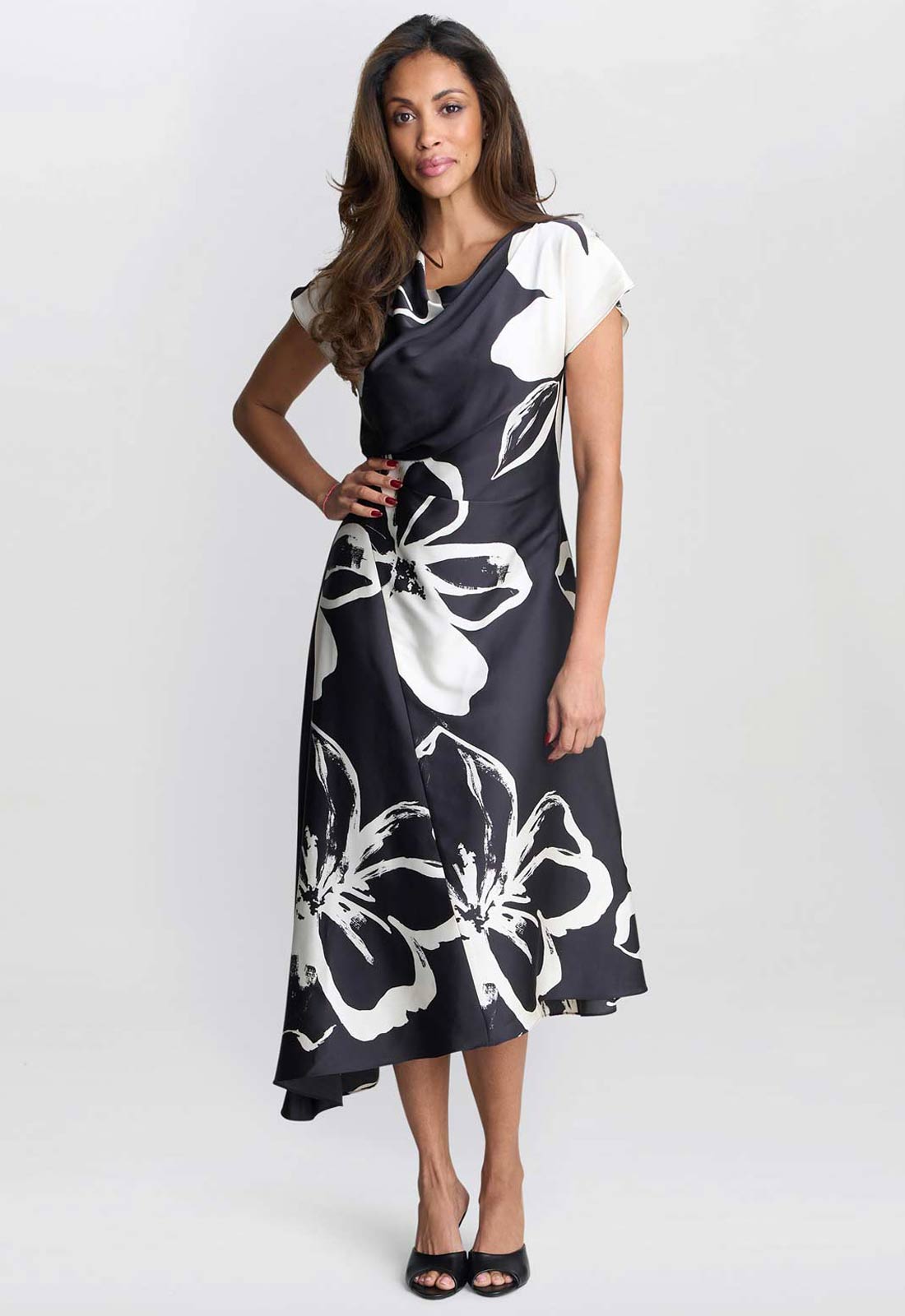 Woman wearing a black dress with white floral patterns on a white background