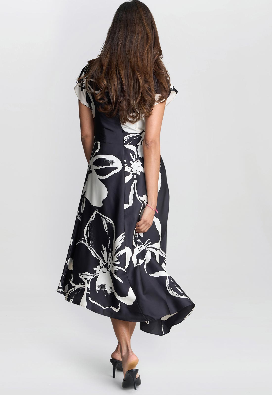 Woman wearing a black floral dress on a white background
