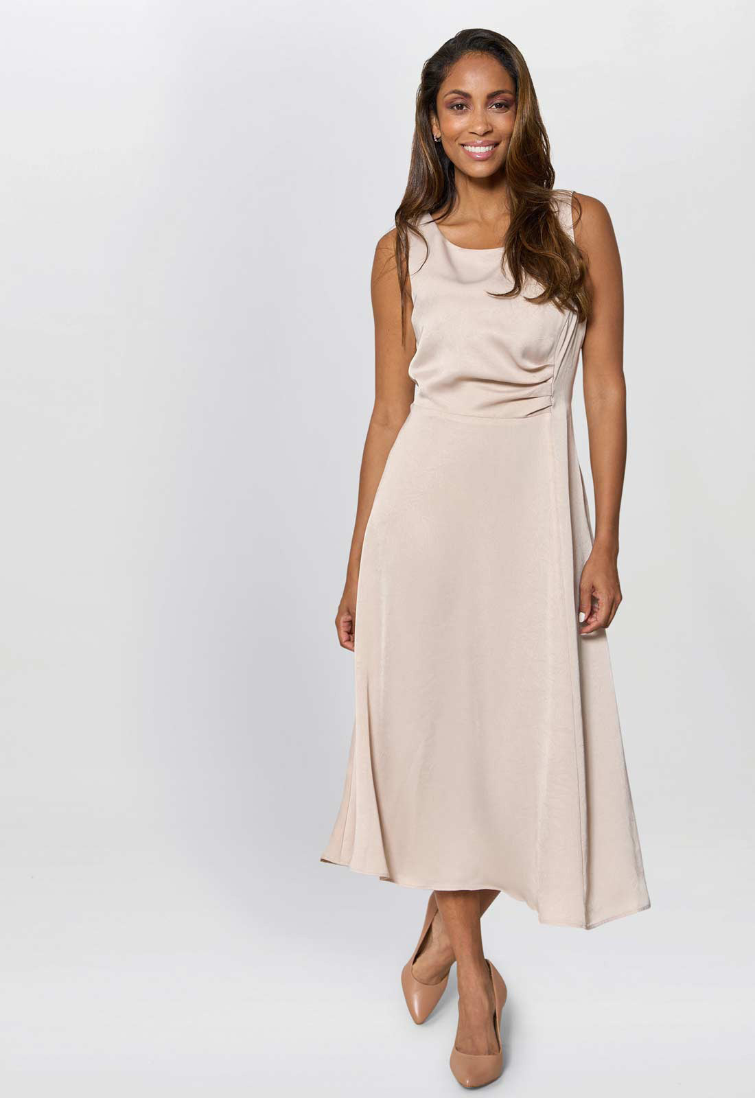 Woman wearing a beige sleeveless dress on a white background