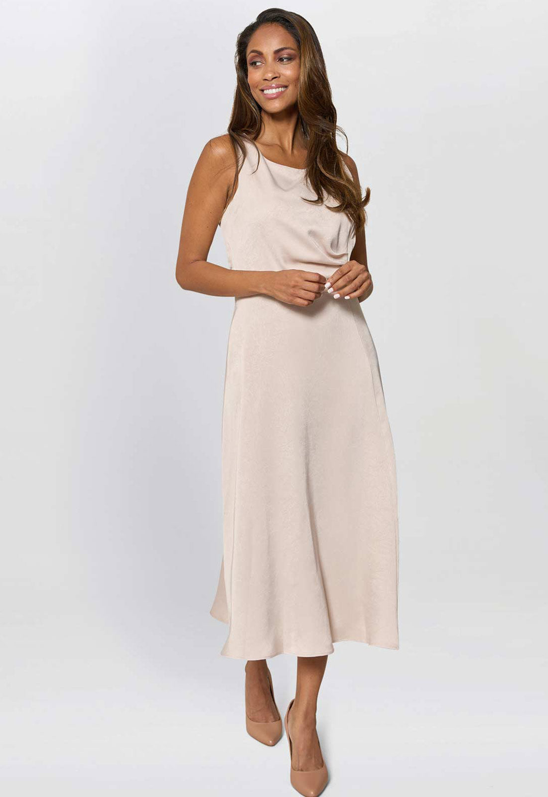 Woman wearing a beige sleeveless dress on a white background