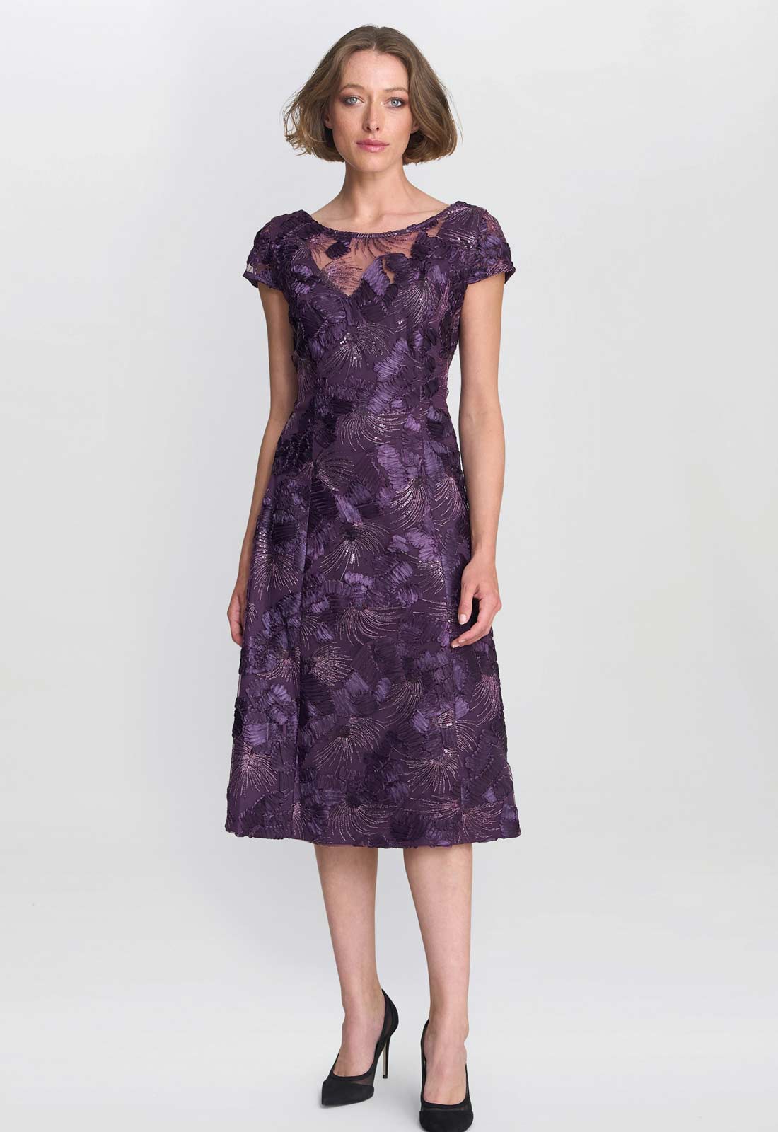 Woman wearing a purple lace dress on a white background