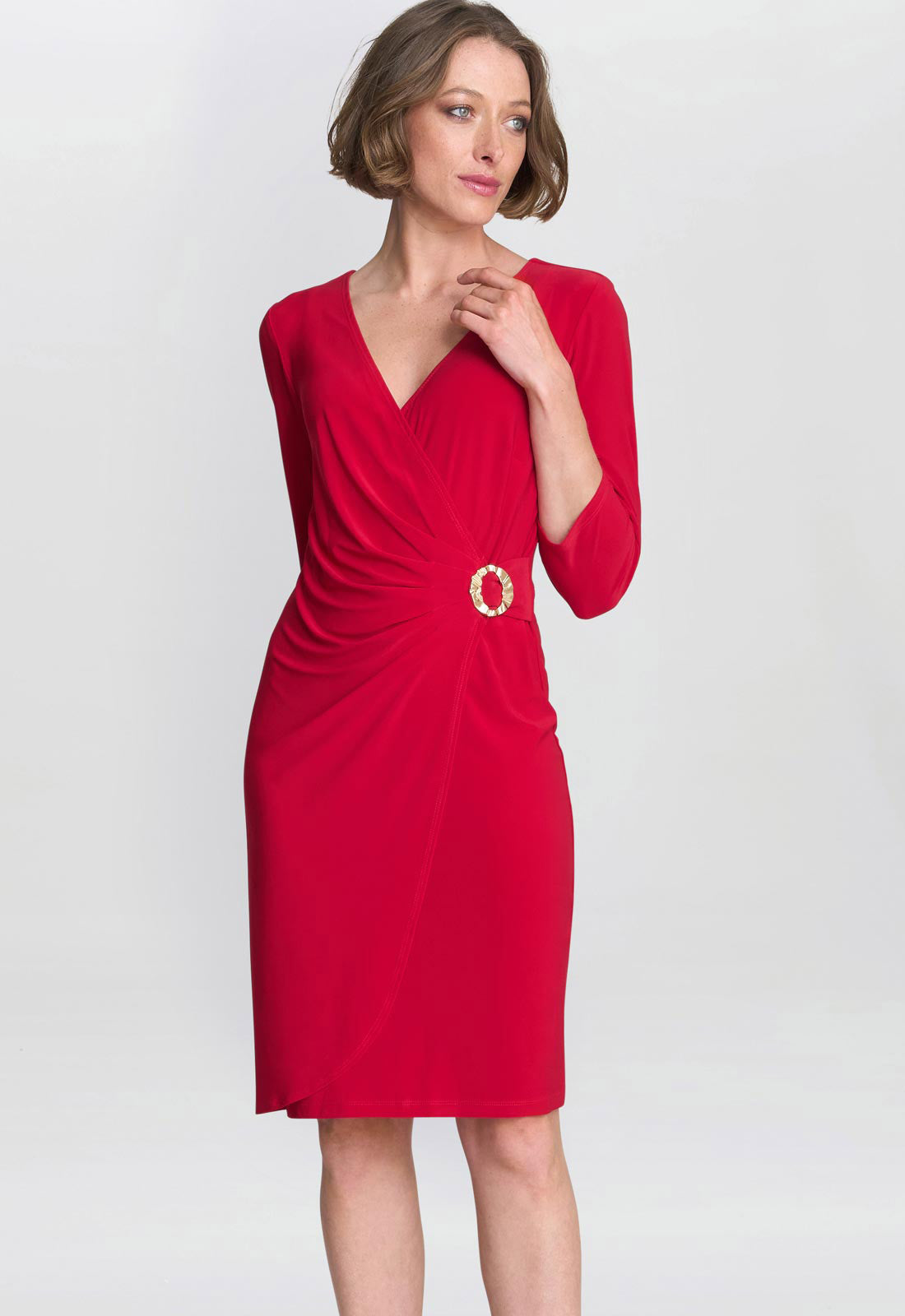 Woman wearing a red dress with a belt on a white background