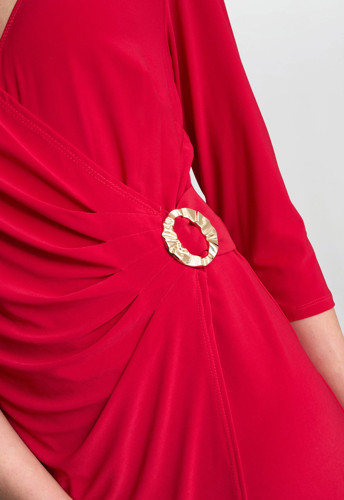 Red dress with a gold circular detail on a gray background