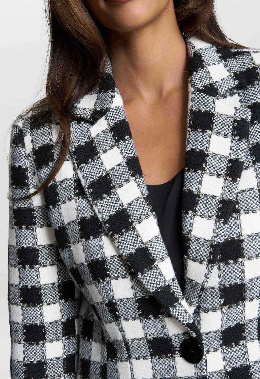 Black and white checkered blazer worn by a person on a plain background