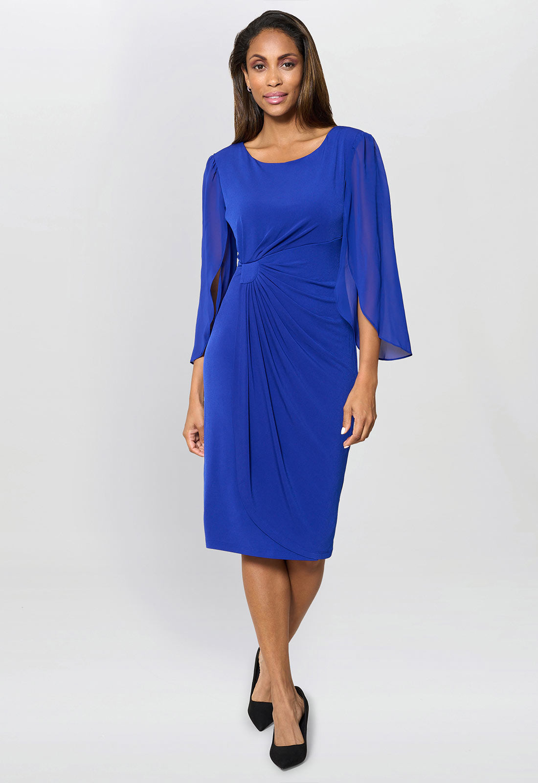 Woman wearing a blue dress with cape sleeves on a white background