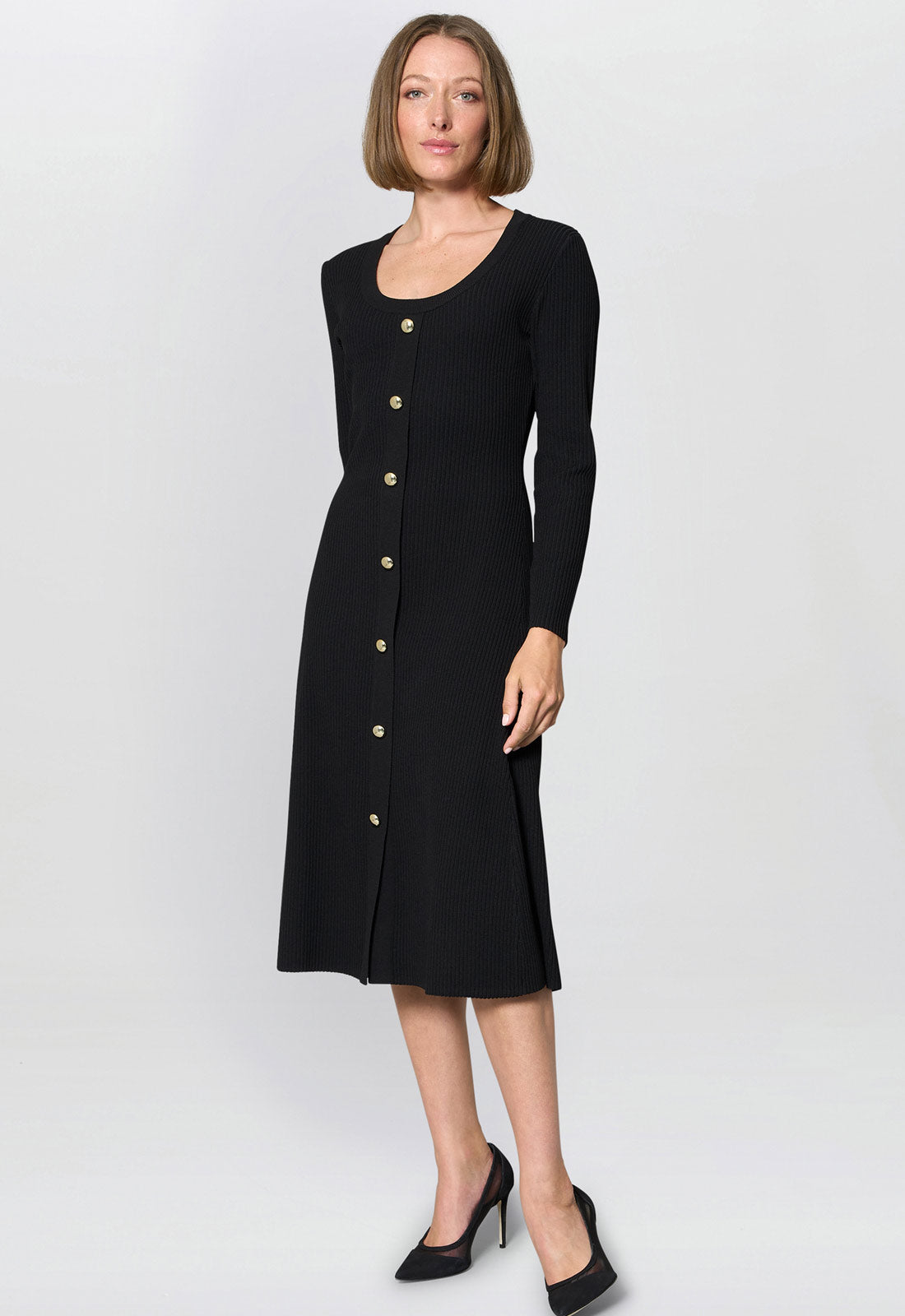 Woman wearing a black dress with gold buttons on a white background