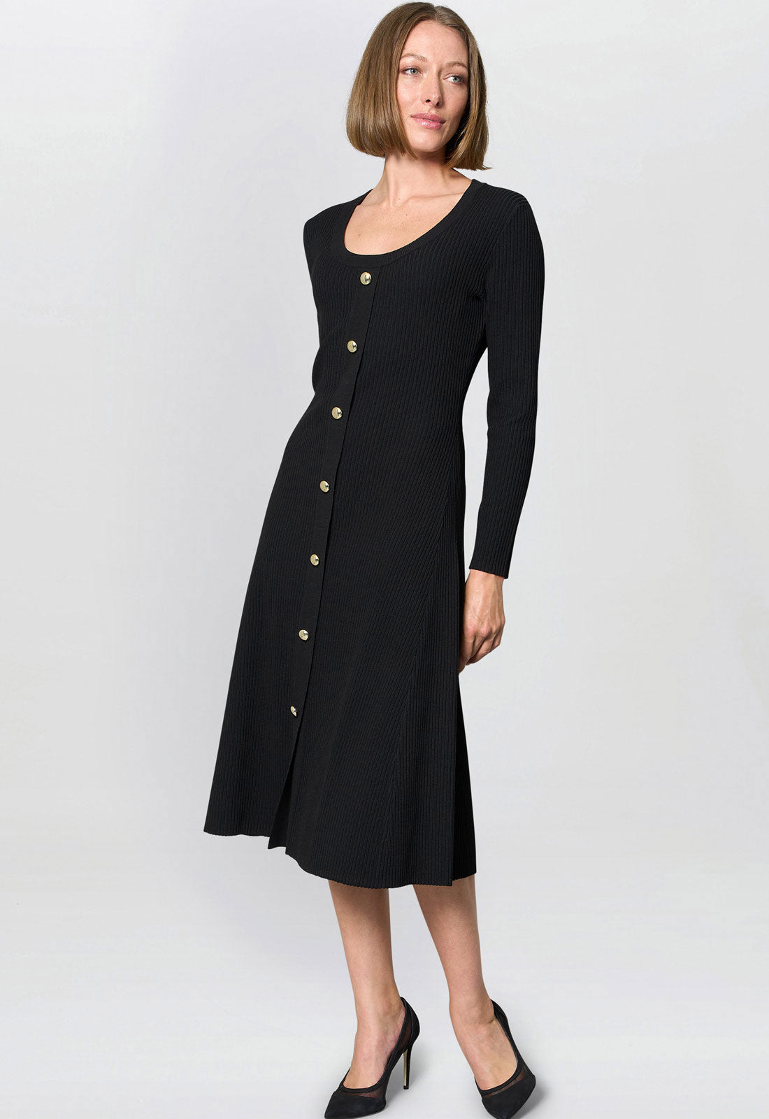 Woman wearing a black dress with buttons on a white background