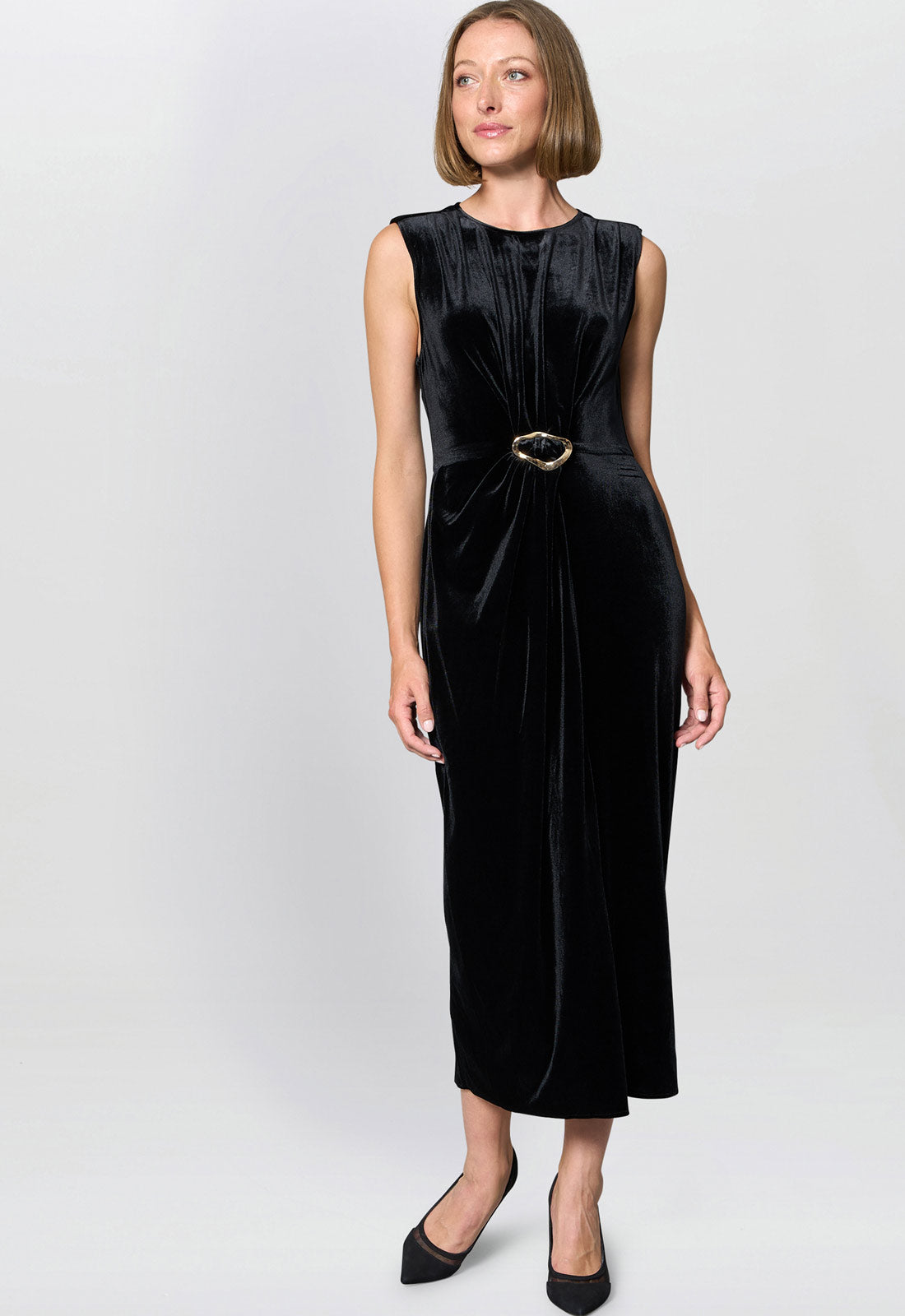 Woman wearing a black sleeveless dress with a belt on a white background