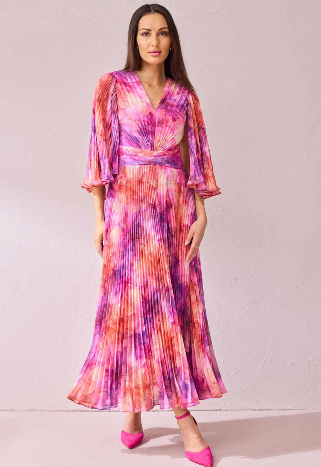 Woman wearing a colorful tie-dye dress with a plain background