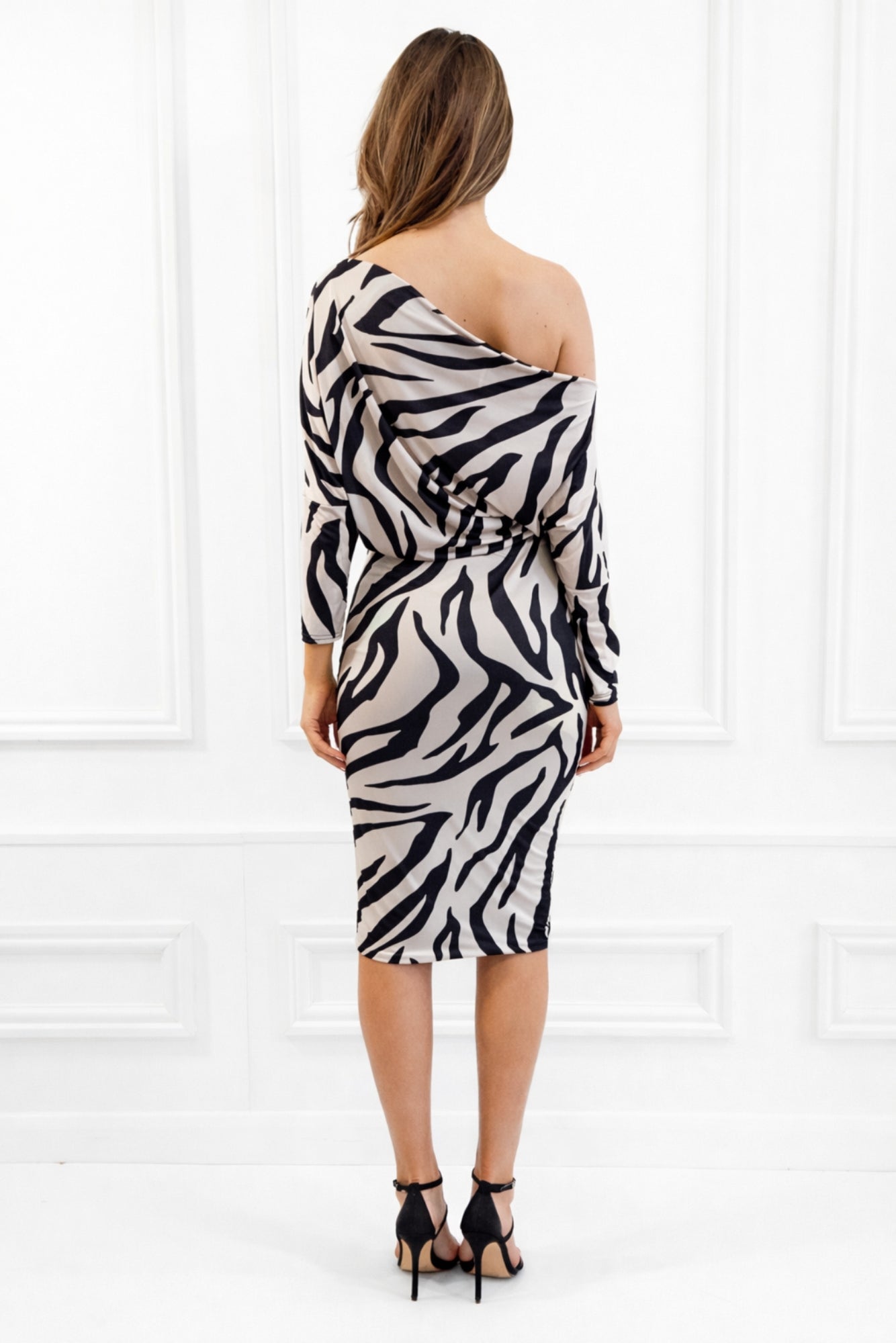 Woman wearing a zebra print dress against a white background
